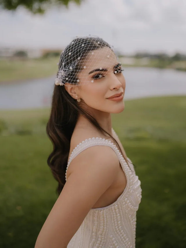 Bride wearing a white pearl birdcage veil for her court wedding