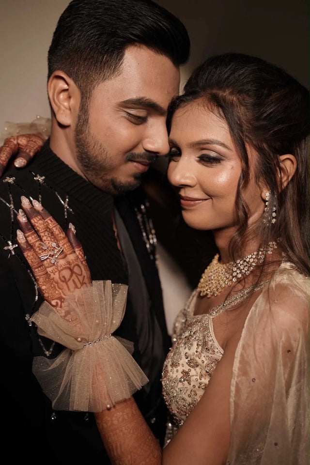 Bride wearing sheer ruffled gloves beside her partner for her sangeet